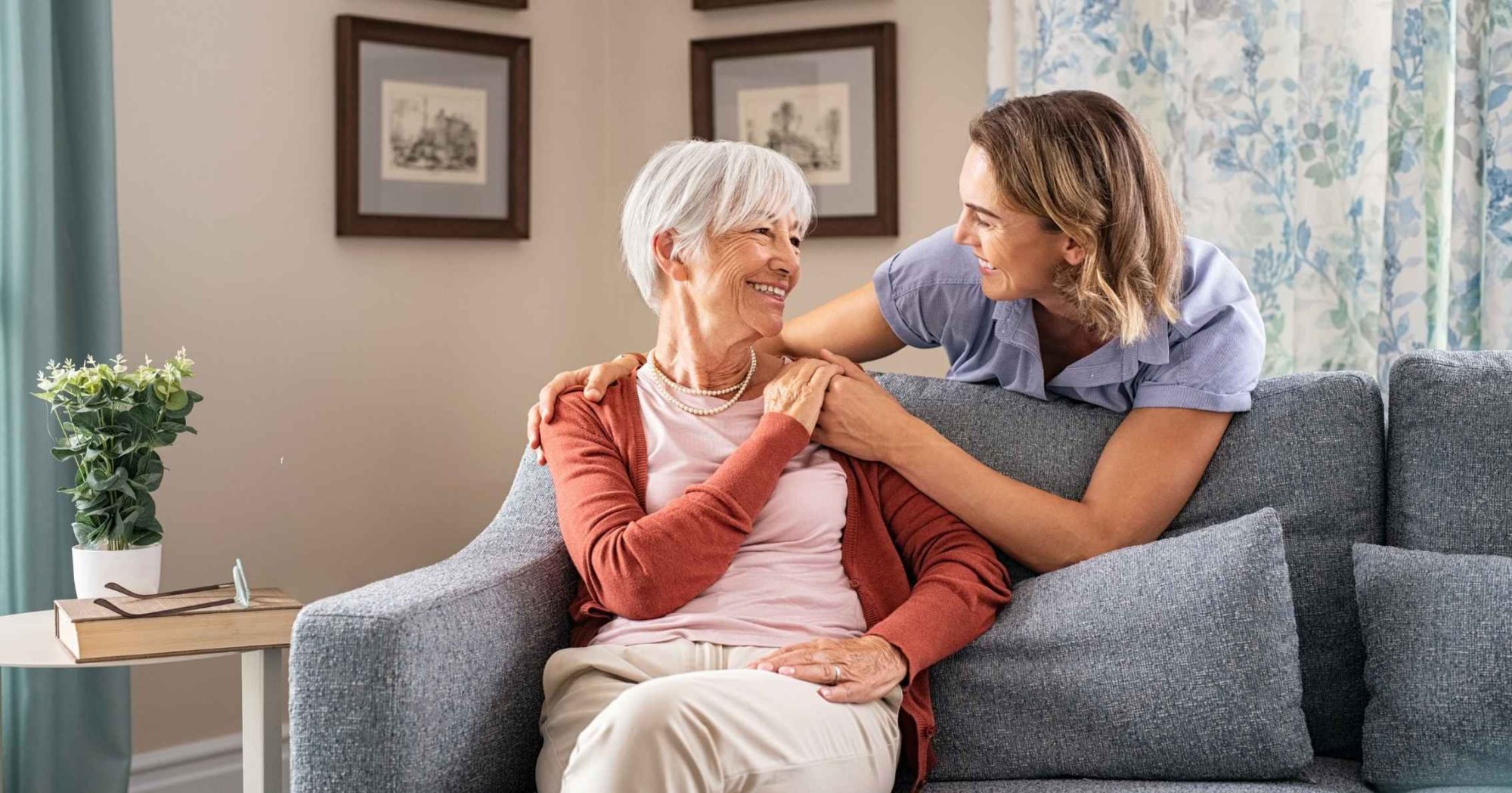 Young woman comforting an elderly woman on a couch – Eleven Legal enduring guardianship services