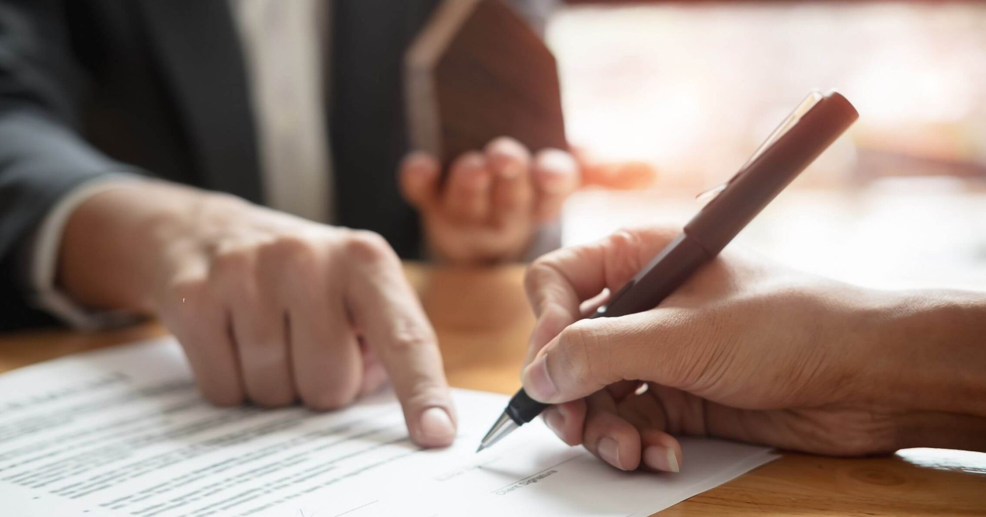 Person signing a legal document with a lawyer – Eleven Legal will preparation services