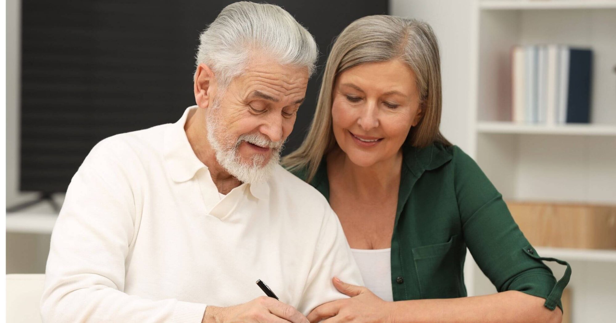 Smiling elderly couple signing legal documents – Eleven Legal probate services