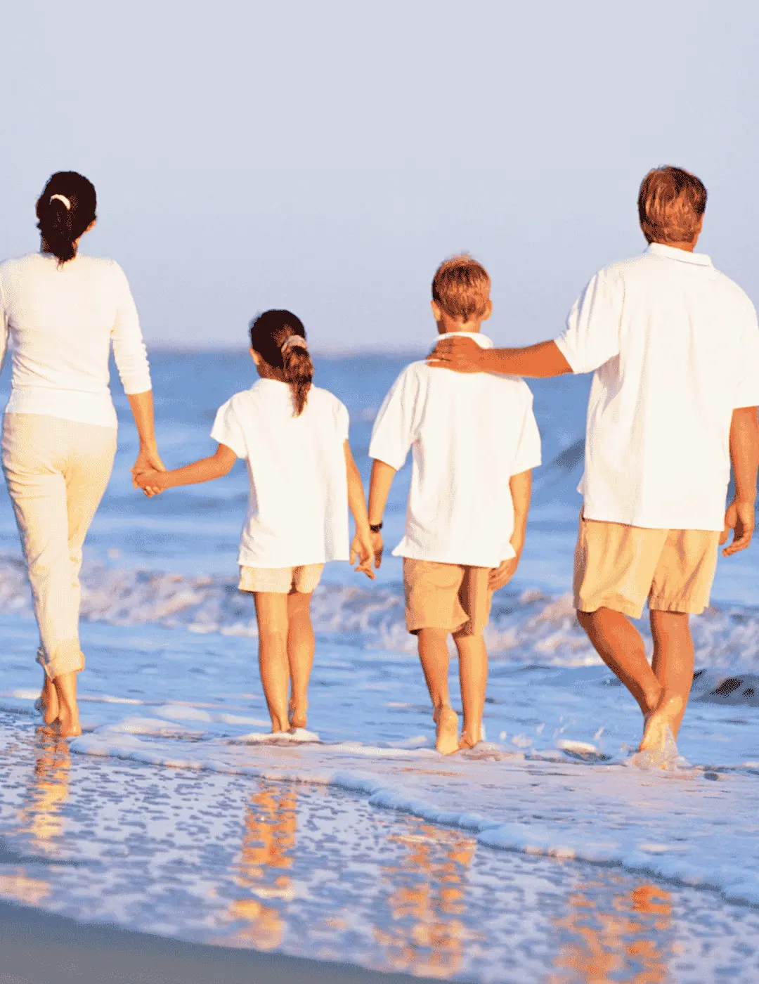 Smiling parents and children on the beach, symbolizing protection and wealth preservation through testamentary trusts.