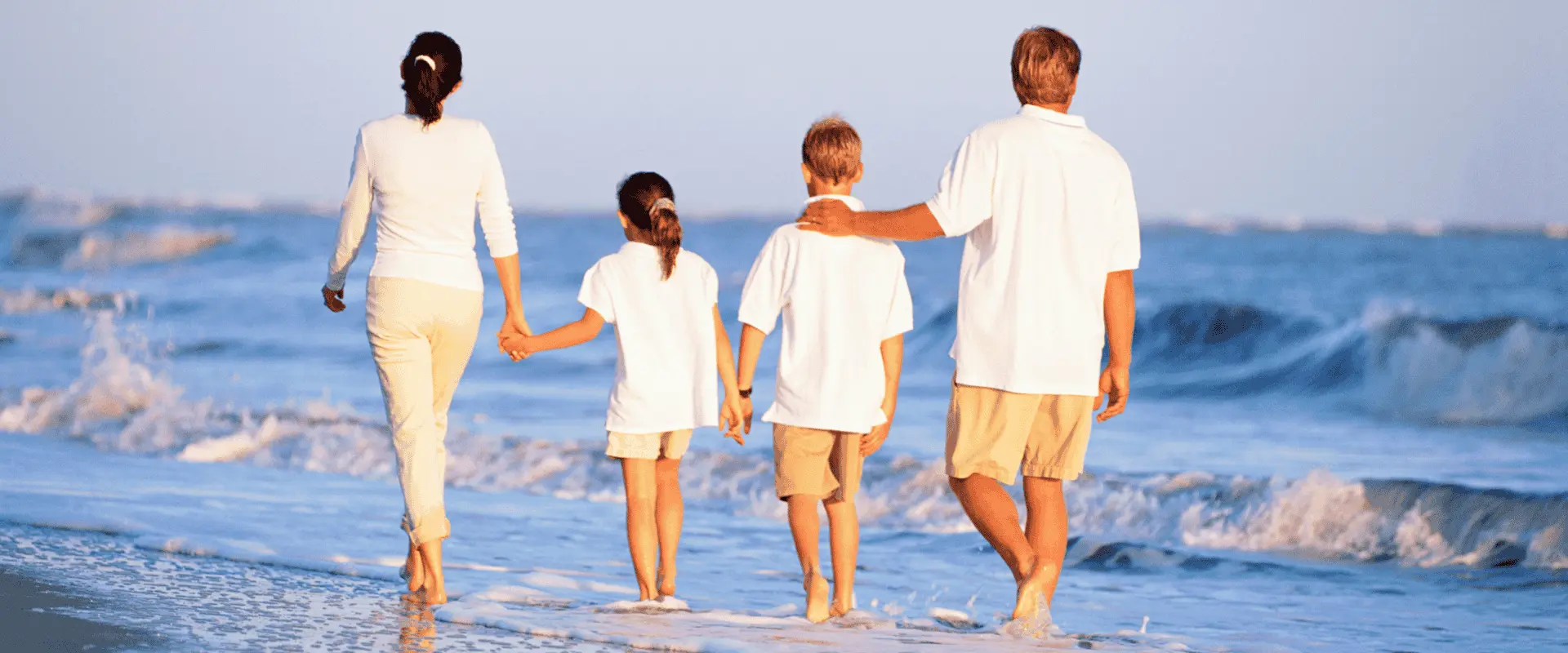 Happy family walking along the beach, representing financial security and estate planning with testamentary trusts