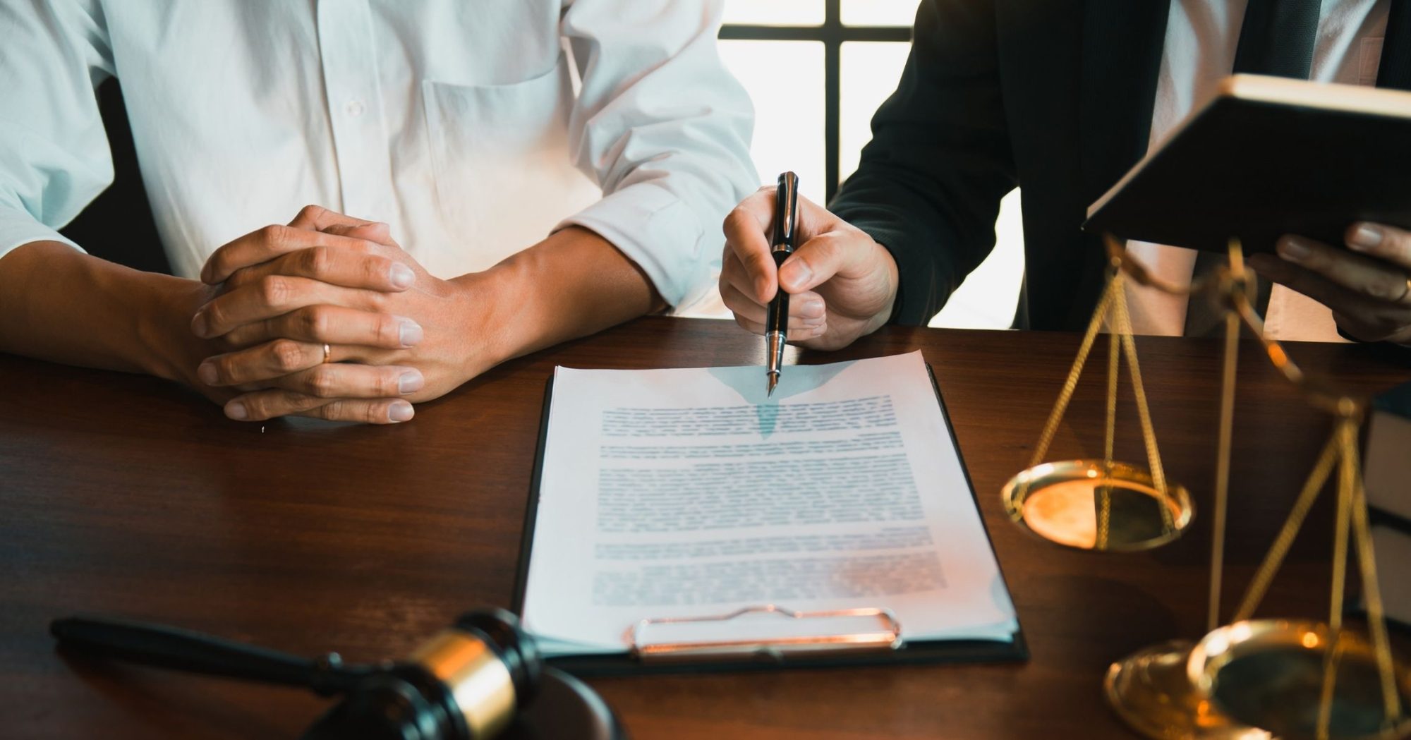 Lawyer discussing a legal document with a client at a desk – Eleven Legal litigation support