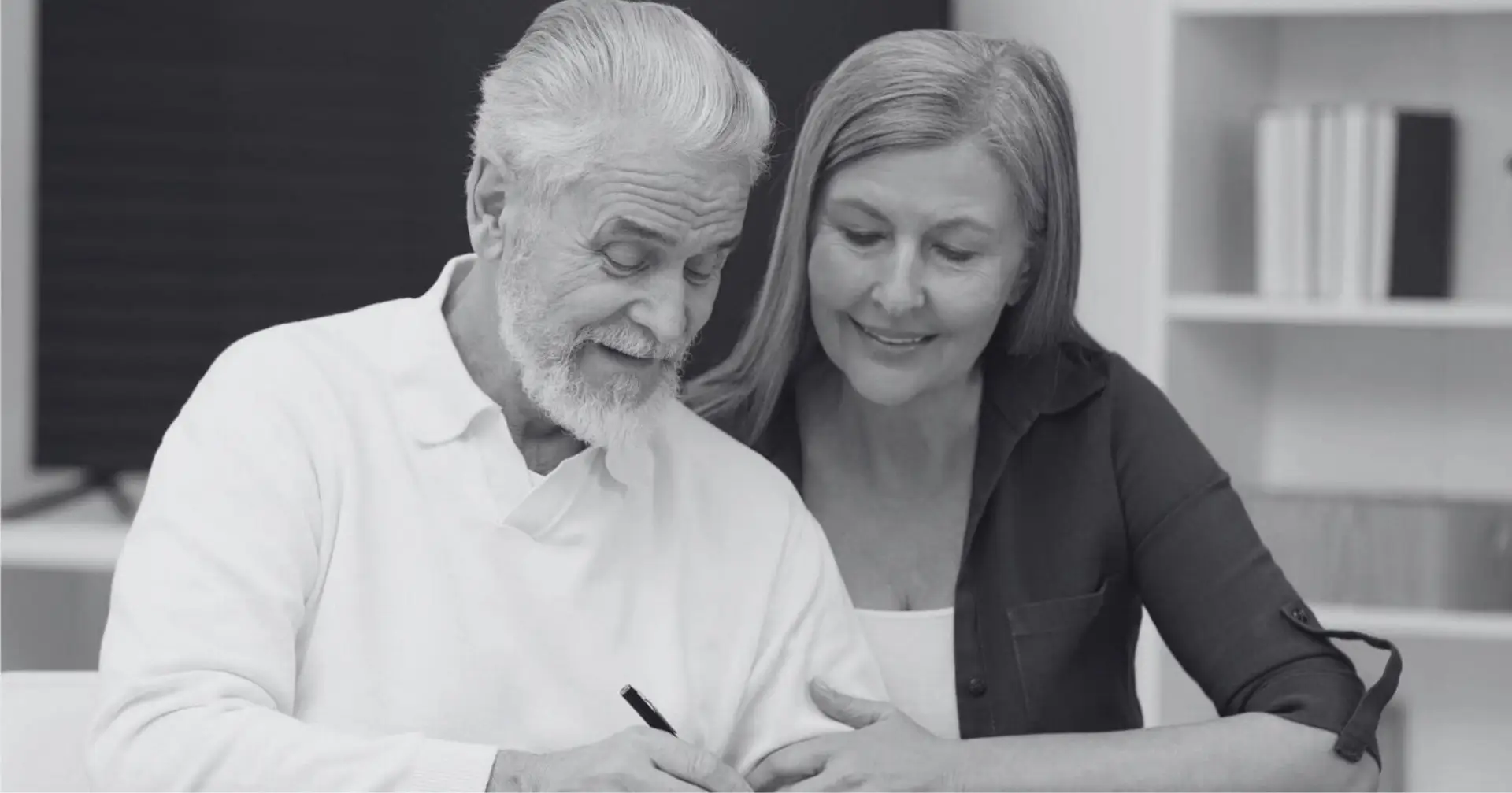 Smiling elderly couple signing legal documents – Eleven Legal