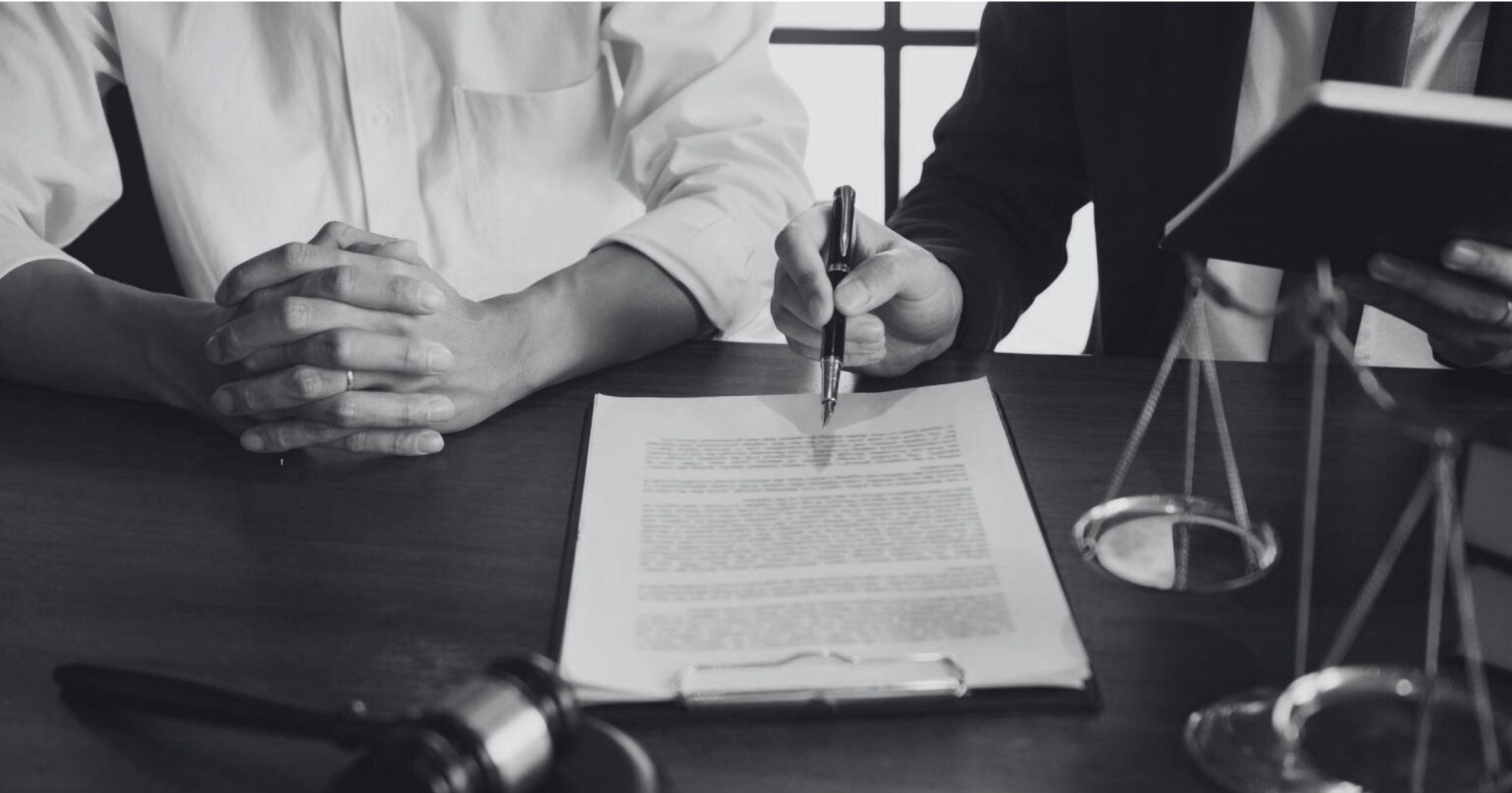 Lawyer discussing a legal document with a client at a desk – Eleven Legal litigation support