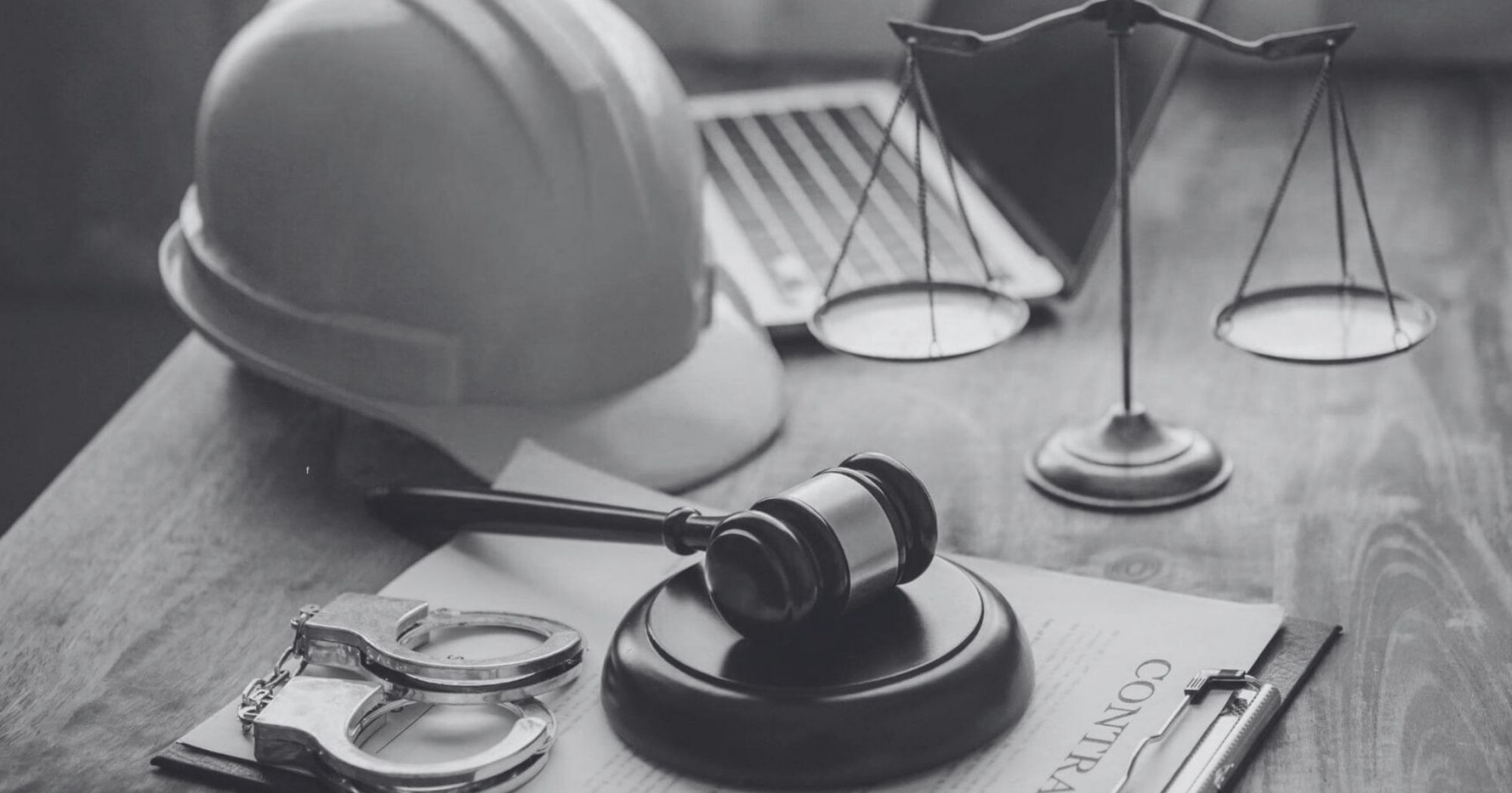 Hard hat, gavel, and scales of justice on a desk – Eleven Legal strata and construction law